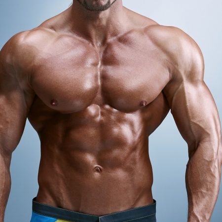 Attractive male body builder on blue background torso of attractive male body builder on blue background.
